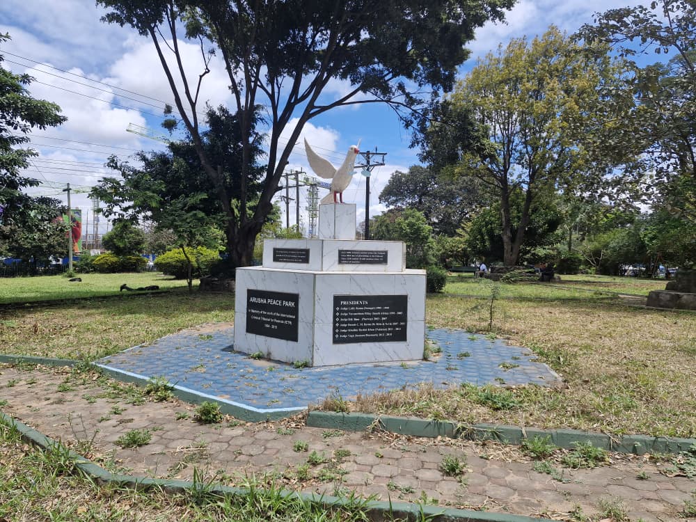 The dove monument at the centre of Arusha Peace Park, with mature trees around it